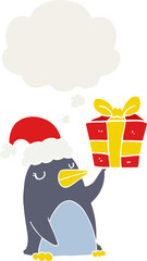 cartoon penguin with christmas present and thought bubble in retro style