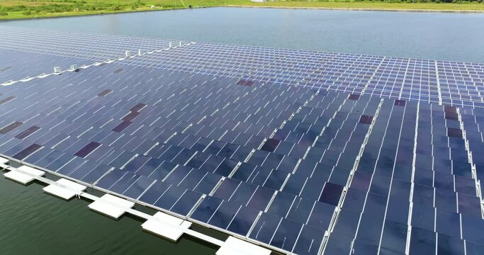 View from above of floating photovoltaic power plant with many rows of solar panels for producing clean electrical energy. Concept of renewable electricity on water surface with no air pollution