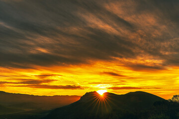 Sunburst, sunstar in the mountains silhouetted