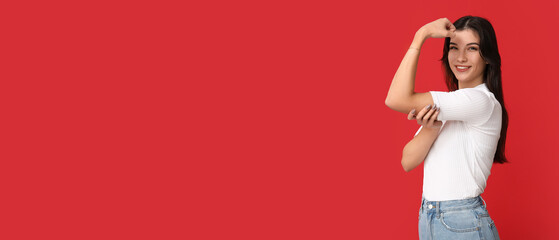 Young woman flexing muscles on red background with space for text. Feminism concept