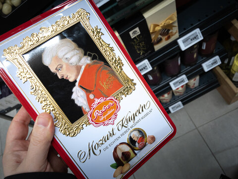 BELGRADE, SERBIA - JANUARY 20, 2024: hands holding a reber mozar kugeln chocolate box in Belgrade. Mozartkugel is a traditional austrian sweet, chocolate balls named after Mozart.