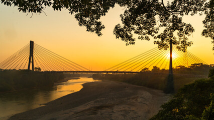 Obraz premium Golden sunset near a river and a bridge