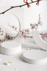 Podiums with blooming branches on white table, closeup. Hello spring
