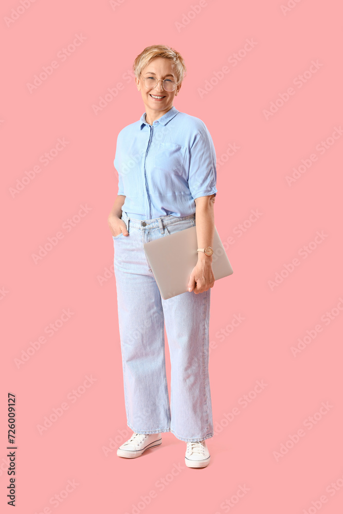 Canvas Prints Mature female programmer with laptop on pink background