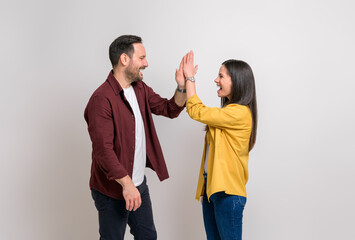 Couple screaming and giving high-five to each other while celebrating victory on white background