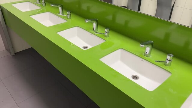 Modern square washbasins in a public restroom