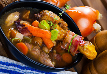 Cock-a-leekie - Scotland national chicken soup with leeks served in black bowl..