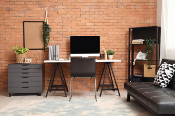 Interior of modern office with workplace, shelf unit and drawers