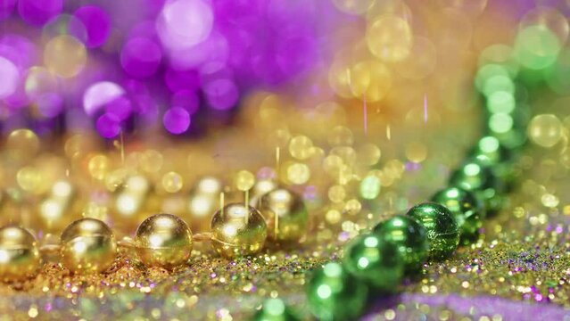 Mardi Gras background with sparkling green, purple, and gold beads, Glittering festive Mardi Gra background.