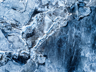 Beautiful view of the frozen river from above. Ice cubes floating on top of the river.
