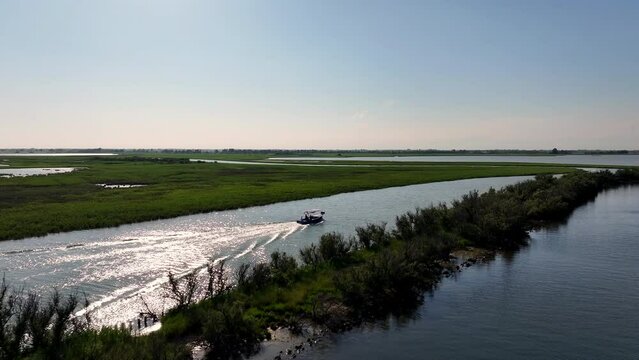 drone view of a motorboat in the marano's lagoon on sunset