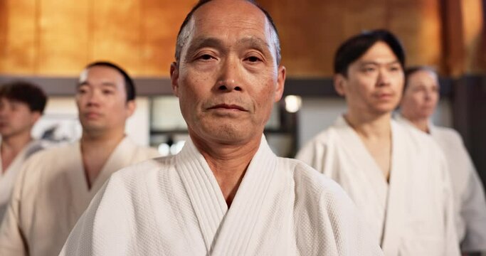 Black belt students, bow or sensei in class for aikido practice, discipline or self defense. Combat demonstration, Japanese people learning or ready to start training for fighting class or education