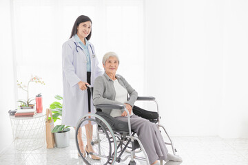 Fototapeta na wymiar Asian health worker drive a wheelchair of old patient, doctor and old female talk about disease symptoms and treatment plan, happy hospital, rehabilitation activity, elderly healthcare promotion