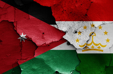 flags of Jordan and Tajikistan painted on cracked wall
