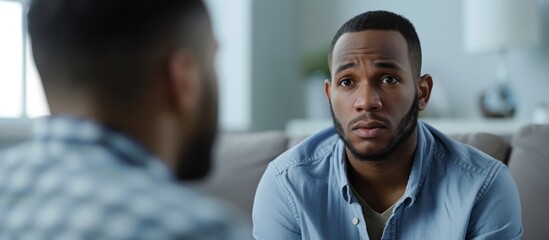 Obraz premium Black man with depression seeks therapy from professional psychologist.