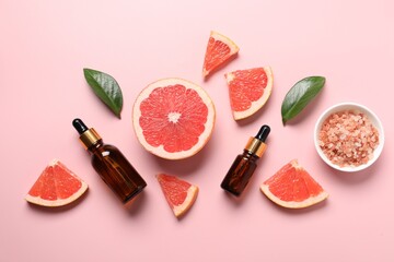 Flat lay composition with grapefruit essential oil on pink background