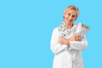 Mature female doctor with tulips and figure 8 on blue background. International Women's Day celebration