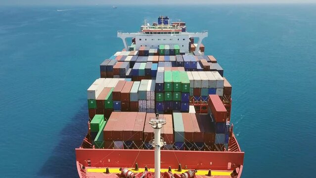 Close up, low level tracking over container ship from nose side to center and stern. 1 minute, full length footage of 300x48 meters long and width cargo ship underway Black Sea