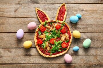 Composition with tasty pizza and eggs on wooden background. Easter celebration