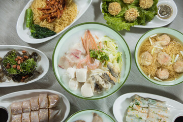 chinese breakfast assorted congee and rice skin side dishes with pork, shrimp and fish ball in restaurant