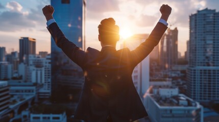 handsome businessman boss in a suit standing in his modern business company office at a window with skyscraper in background. raising his hands up from success and happiness. wallpaper background