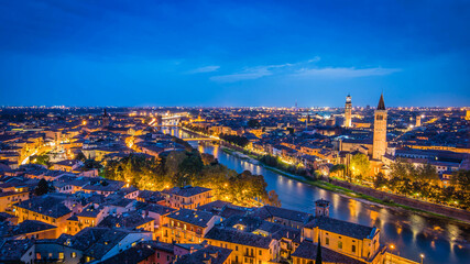 Spectacular night view of historic Verona town with the Adige river, brilliant city lights and deep...