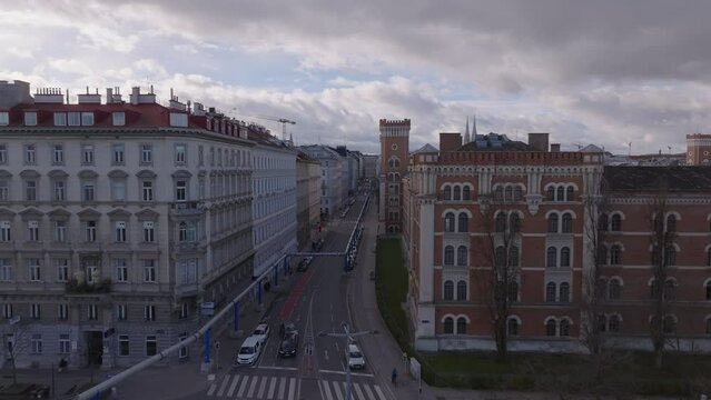 Forwards fly above street along Rossauer Kaserne, historic complex of military barracks. Vienna, Austria