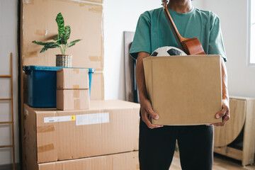 Man carrying cardboard box full of stuff moving in new house - Powered by Adobe