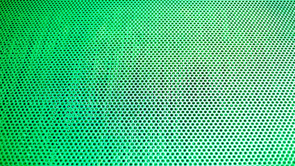 Green metal background with holes. Texture of metal sheet with holes.
