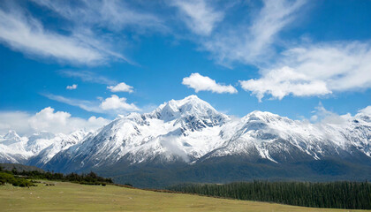 snowy mountain, the sky is clear with a bright blue sky and puffy white clouds; suitable for background or wallpaper