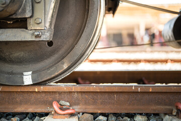 Heavy steel of train wheel on the track, transportation equipment. Close-up and selective focus on the vehicle part.