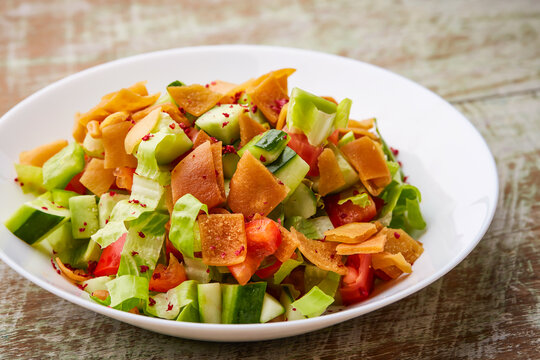 Fatoosh salad or fatoush with cucumber, tomato, carackers, cabbage and leaves served in dish isolated on table top view of arabic food