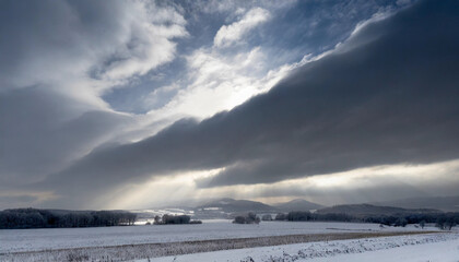Fototapeta na wymiar Fantastic winter landscape with snow covered field and dark stormy sky