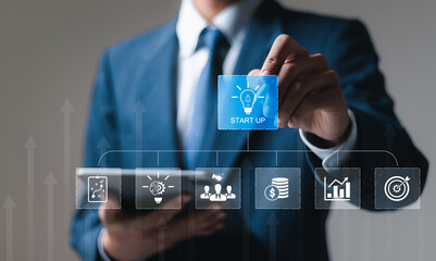 Startup business concept, Businessman touching virtual screen of startup icon for fast strategic planning and business success.
