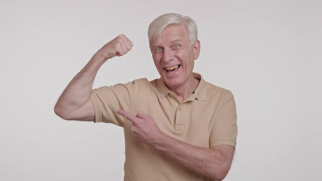  positive strong old man showing his hands power demonstrating biceps 