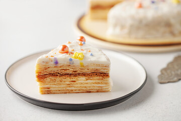 Slice of layered honey cake in plate on table