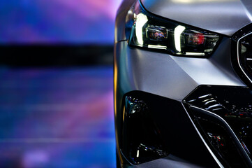 Front view of LED headlights super car on black background, free space on left side for text
