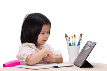Asian Smiling preschool Child Girl happily engages in drawing and learning with colorful pencils and a laptop in a school setting, embodying the joy of childhood education and creative exploration.