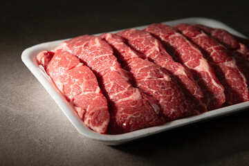 Sliced raw meat on dark background