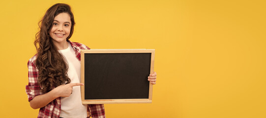 happy kid pointing finger on school blackboard for copy space, education. Banner of school girl student. Schoolgirl pupil portrait with copy space.
