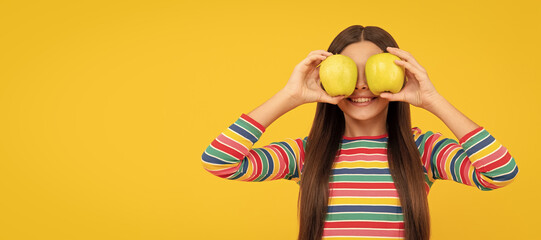 Apples improve your eyesight. Happy child hold apples at eyes. Fruit for good eye health. Child girl portrait with apple, horizontal poster. Banner header with copy space.