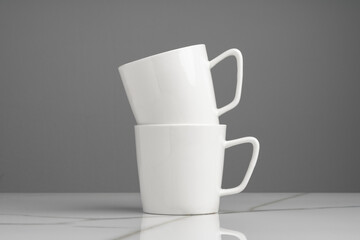 Ceramic cups on marble table against gray background