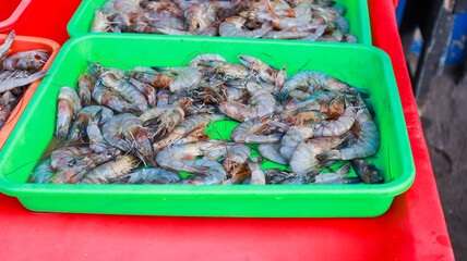 Piles of fresh sea shrimp with various sizes caught by fishermen are on display for sale at the...