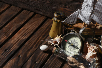 Sea travel or piracy concept background. Sea ship boat, compass and compass on the wooden desk...