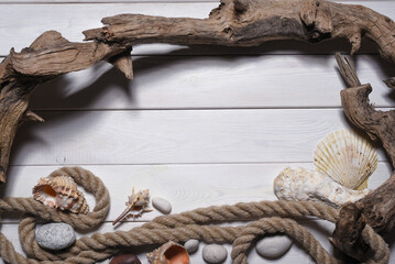 Seashells, mooring rope and pebble stones on the white wooden desk table background top view. Sea travel flat lay concept background with copy space.