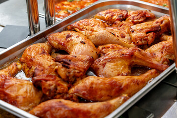 Metal tray with fresh baked chicken in a canteen