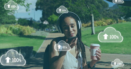 Image of clouds with arrows over woman talking on smartphone in a park