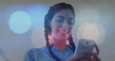 Image of latino businesswoman using smartphone over city lights