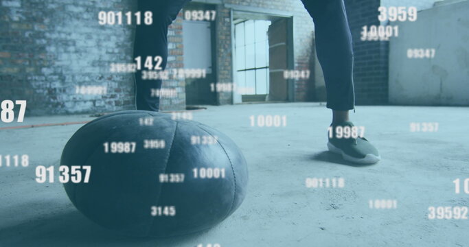 Image of floating numbers over man exercising with a ball - Powered by Adobe