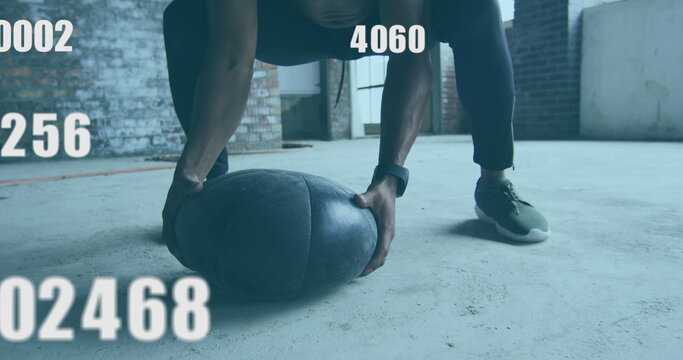 Image of floating numbers over man exercising with a ball